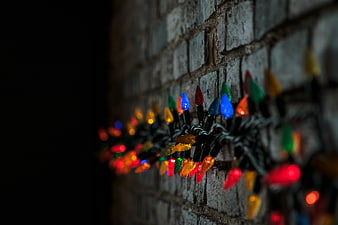 Colorful Christmas lights on a brick wall at night