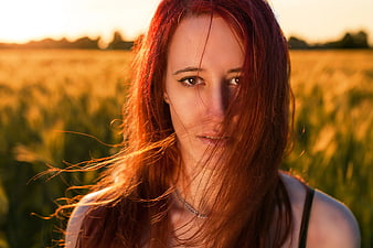 Portrait of Redhead Woman in Golden Wheat Field at Sunset