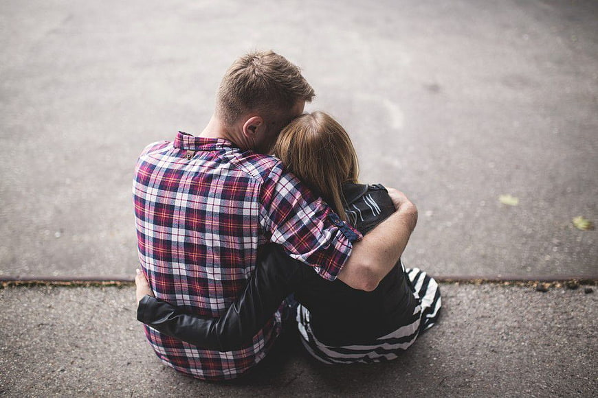 Young Couple Cuddling on Pavement from Above