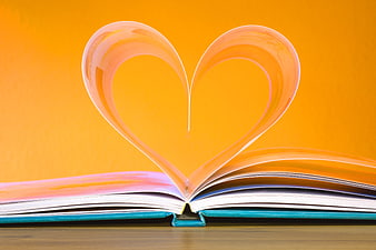 Open Book Pages Bent into Heart Shape on Orange Background