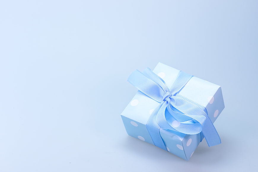 Blue Polka Dot Gift Box with Ribbon on Light Background