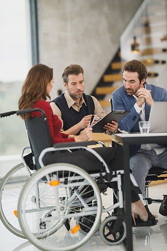 Business meeting with woman in wheelchair discussing documents