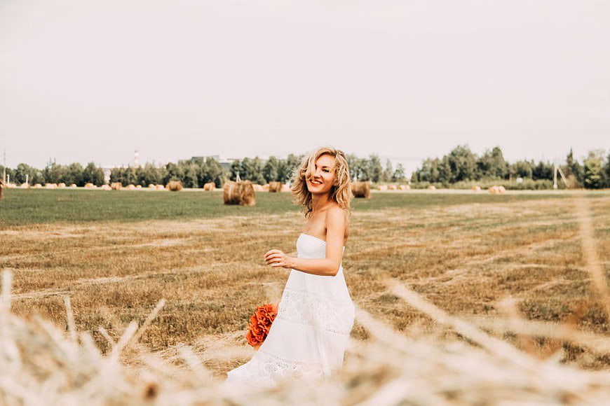 Blonde Woman in White Dress Walking Through Harvested Field