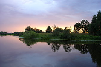 Serene River Landscape at Sunset with Tree Reflections