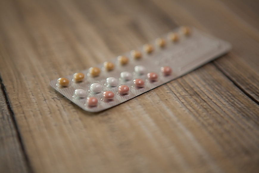 Blister pack of birth control pills on rustic wooden table