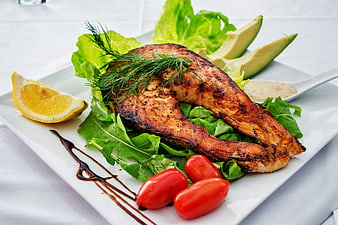 Grilled Salmon Fillet with Salad and Avocado on White Plate