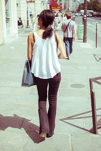 Woman Walking Away on City Sidewalk with Shopping Bags