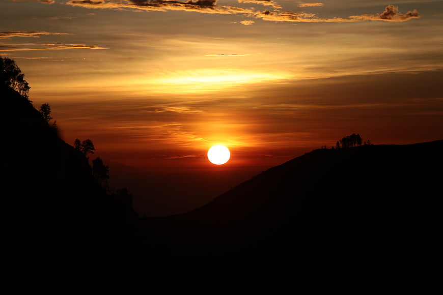 Golden sunset over silhouetted mountain landscape