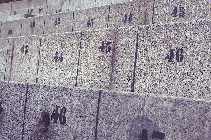 Close-up of numbered concrete stadium seats