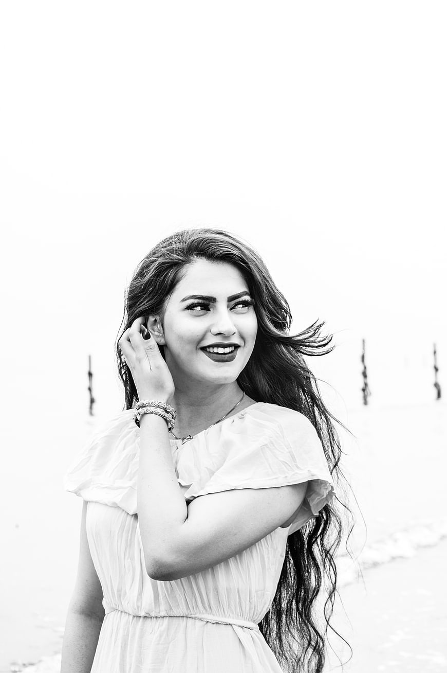 Happy woman smiling in black and white portrait outdoors