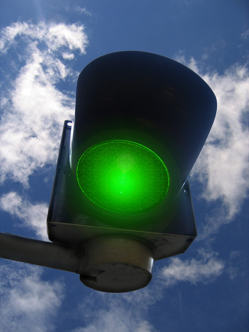 Low Angle Green Traffic Light Signal Against Blue Sky