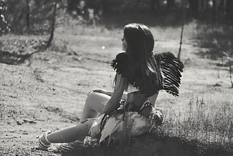 Black and white portrait of girl with angel wings in forest
