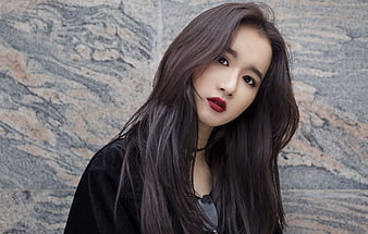 Portrait of young Asian woman with long dark hair and red lipstick