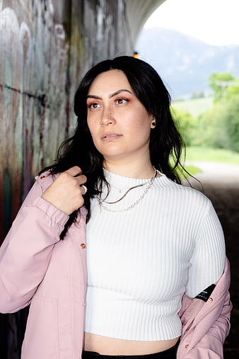 Portrait of woman in pink jacket and white top outdoors