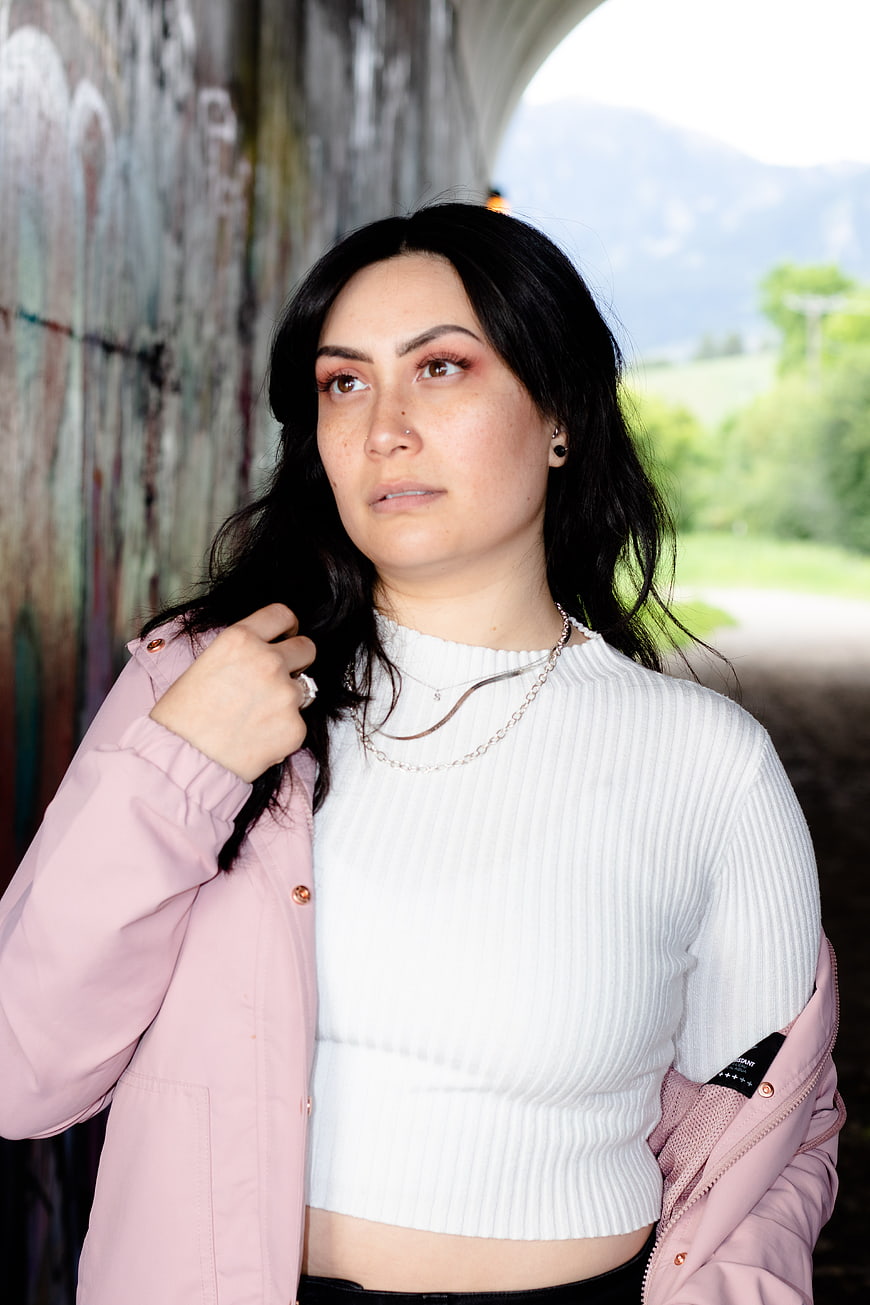 Portrait of woman in pink jacket and white top outdoors