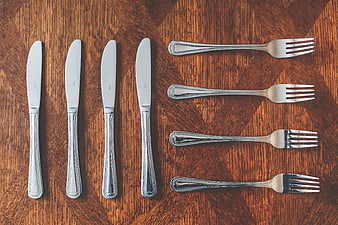 Silver knives and forks on wooden table