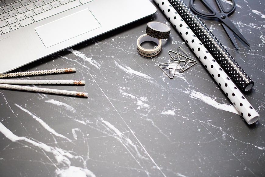 Flat lay of office supplies on gray marble desk