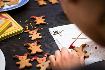 Child decorating Easter bunny gingerbread cookies with red icing