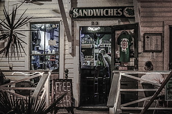 Rustic Sandwich Shop Exterior with Patrons and Free Beer Sign