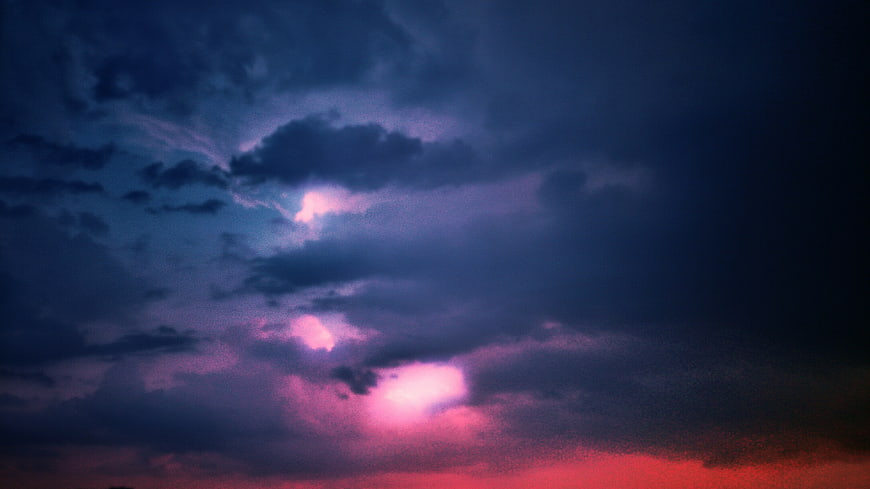 Dramatic purple and pink sunset clouds in dark sky