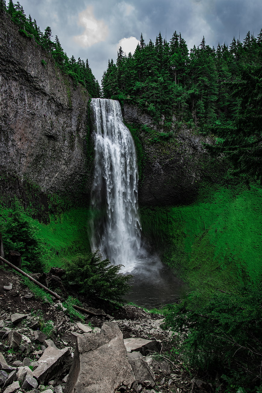 Majestic waterfall cascading down a rocky cliff into a lush green forest