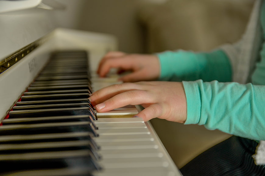 Close-up of hands playing white piano keys