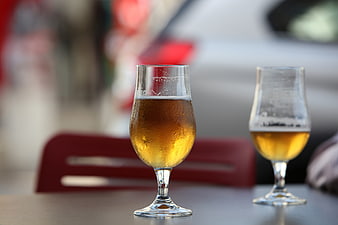 Two glasses of cold beer on a table with blurred background