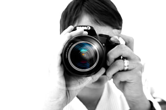Photographer holding DSLR camera with lens flare