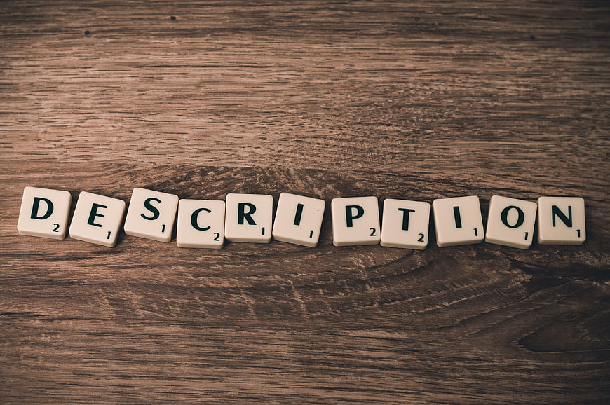Scrabble Tiles Spelling Description on Wooden Background