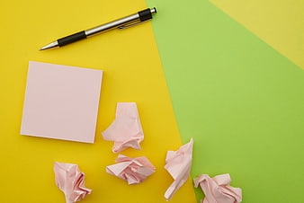 Flat Lay of Crumpled Pink Paper and Pen on Yellow Background