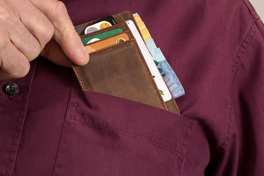 Hand Placing Leather Wallet With Cards And Cash Into Shirt Pocket