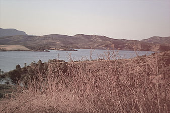 Vintage landscape of a lake surrounded by dry hills and mountains