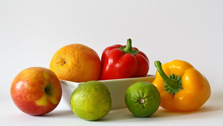Fresh fruits and vegetables arranged on a white background