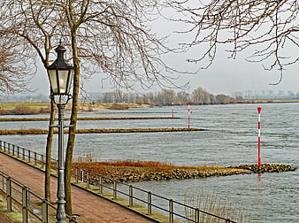 Winter Riverside Promenade with Vintage Lamp Post and River Markers