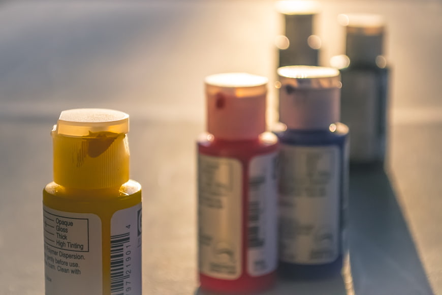 Close-up of colorful paint bottles in a row
