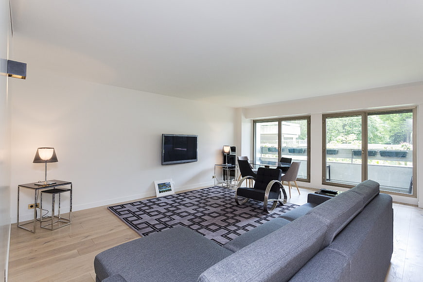 Modern minimalist living room with gray sofa and large windows