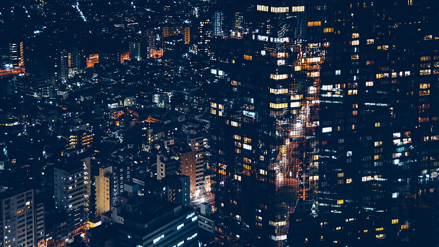 Aerial Night View of Dense Urban Cityscape with Glowing Windows