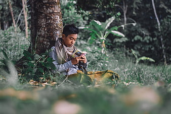 Young Muslim Man Reading Quran Under Tree In Forest