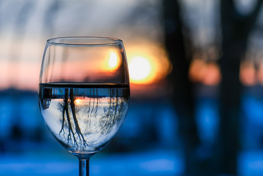 Wine glass with sunset reflection in winter landscape