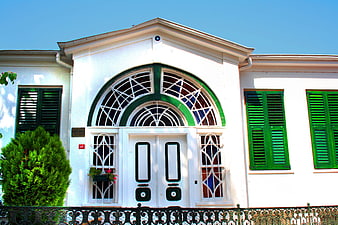 White house with green shutters and arched window