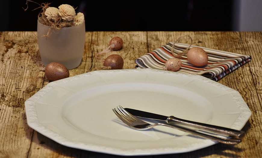 Rustic Easter Table Setting With White Porcelain Plate And Cutlery