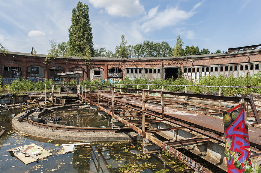 Abandoned industrial site with rusty bridge and graffiti
