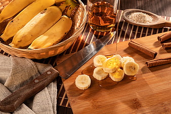 Sliced bananas with honey and cinnamon on wooden board