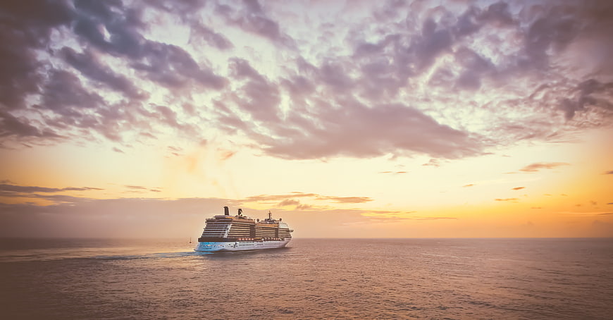 Cruise Ship Sailing on Ocean at Sunset with Dramatic Clouds