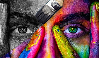 Close-up of face being painted with vibrant rainbow colors