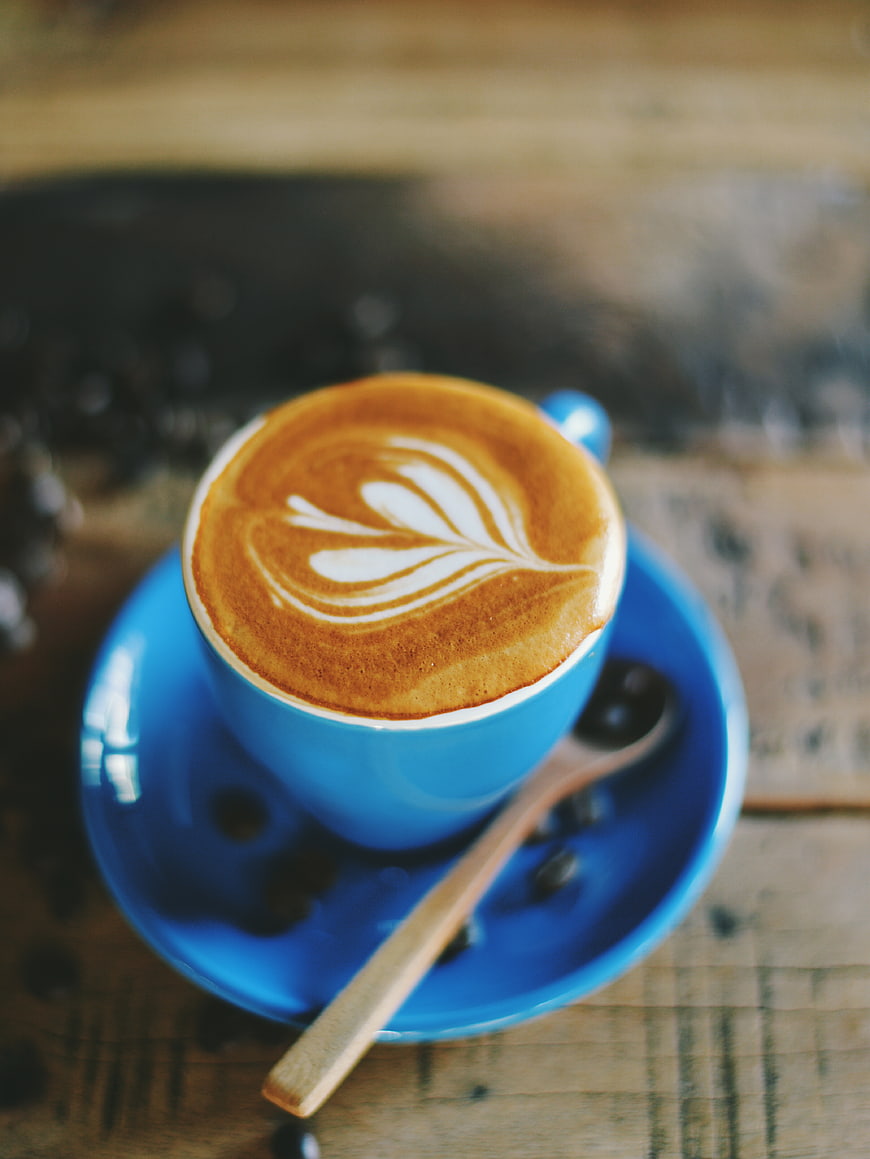 Blue Cup of Cappuccino with Latte Art on Wooden Table