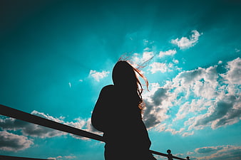 Silhouette of Woman Looking at Blue Sky with Clouds