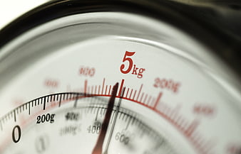 Close-up of analog kitchen scale dial showing 5 kg weight