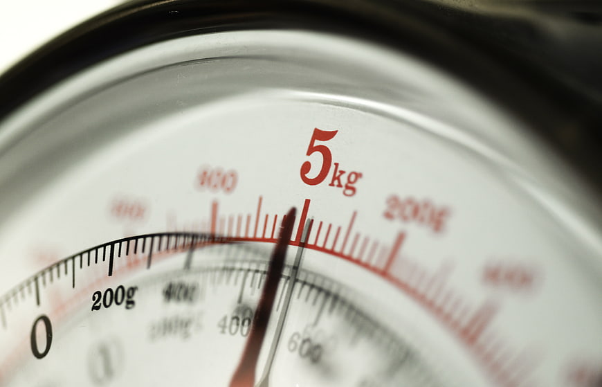 Close-up of analog kitchen scale dial showing 5 kg weight