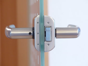 Close-up of modern glass door handle and lock mechanism